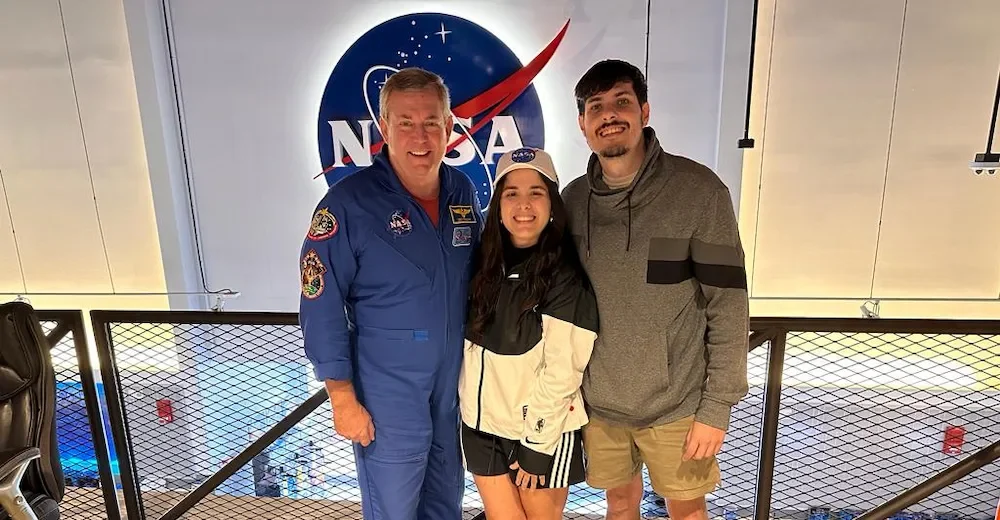 Juli y su novio, Juani, con un astronauta. El hombre lleva un traje azul característico.