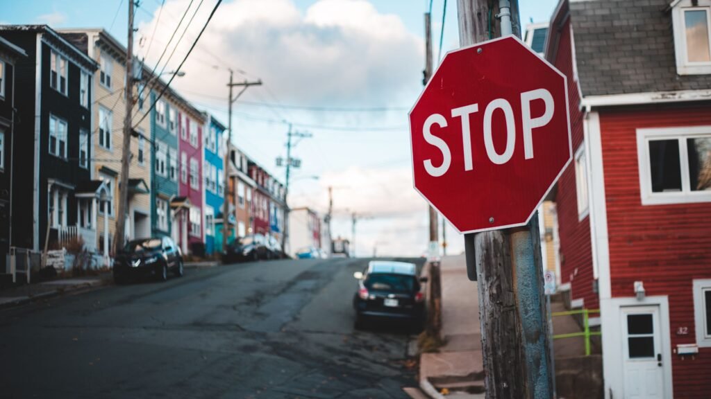 Calle difuminada y como primer plano un cartel rojo de "pare". Dice STOP en mayúscula