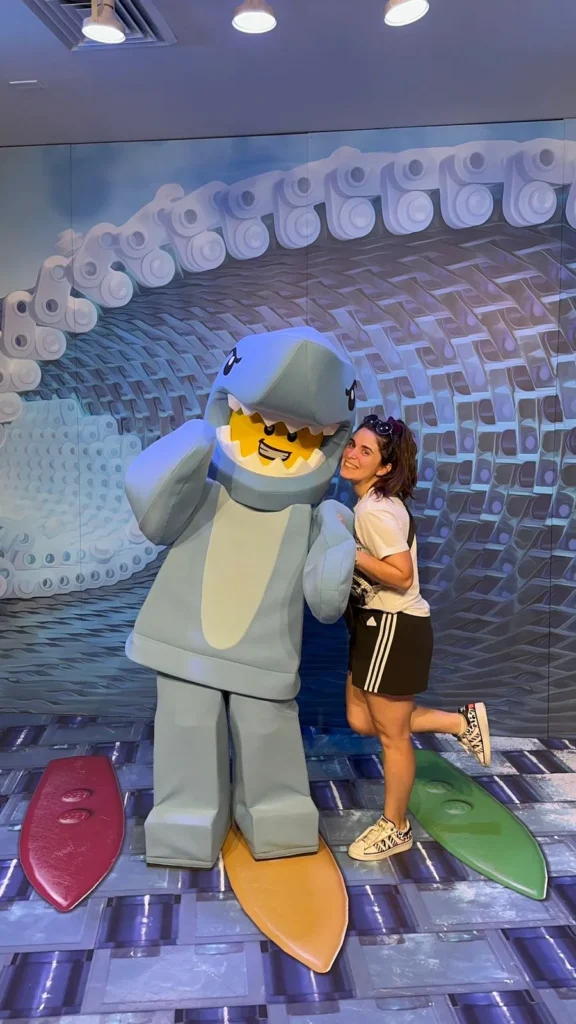 Juli abrazando al personaje de tiburón en una actividad dentro de Legoland Florida