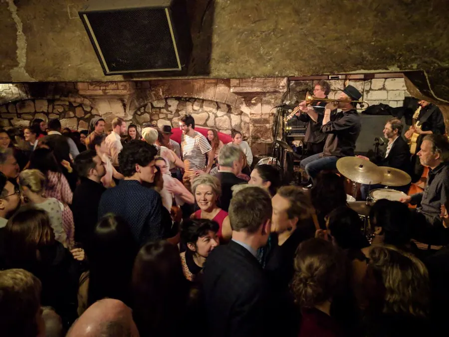 Pintura impresionista de Renoir en el Louvre que muestra a dos niñas leyendo juntas, con suaves pinceladas y tonos cálidos.