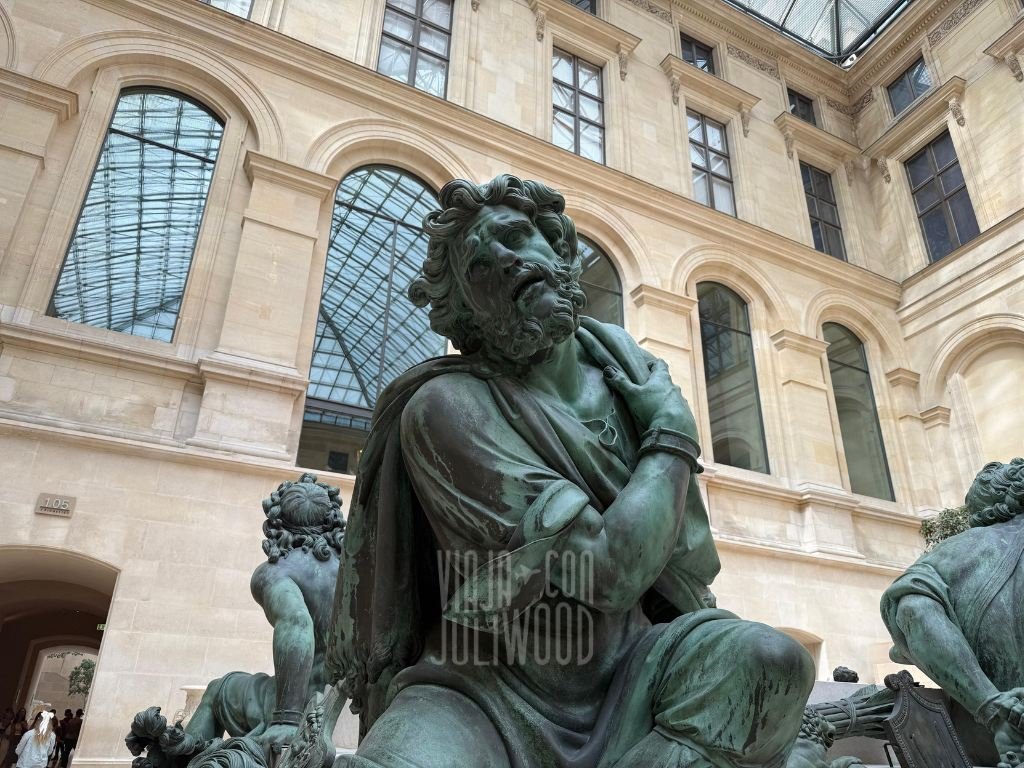 Escultura de uno de los Cuatro Cautivos en el Louvre, un hombre barbudo encadenado que mira hacia un costado con expresión de resistencia.