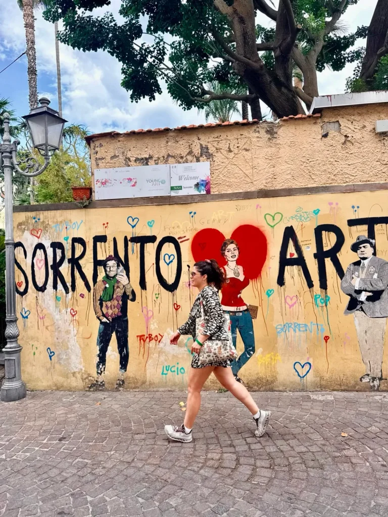 Caminando frente al mural "Sorrento Loves Art" durante una visita por el centro histórico de Sorrento, Italia.