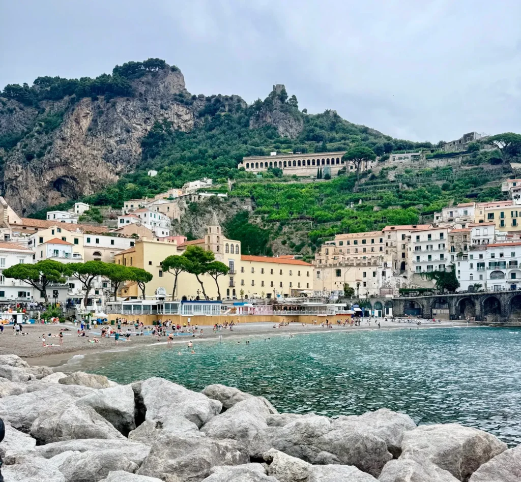 Playa y vista panorámica de Amalfi con sus casas sobre el acantilado en la Costa Amalfitana, Italia.
