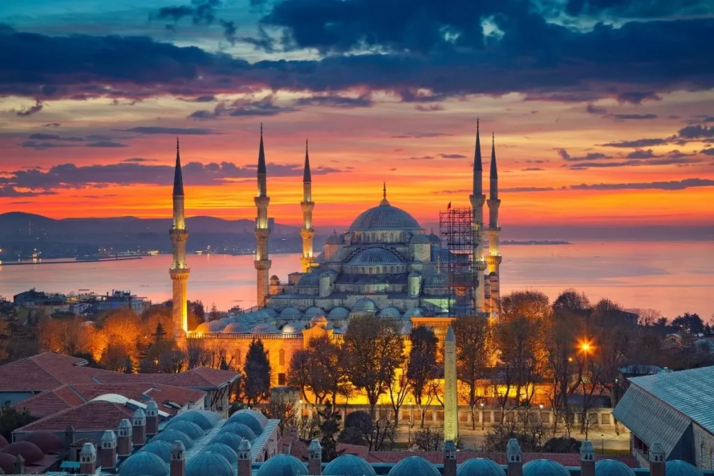 Mezquita Azul de Estambul al atardecer, con sus seis minaretes iluminados y vistas al mar de Mármara, Turquía