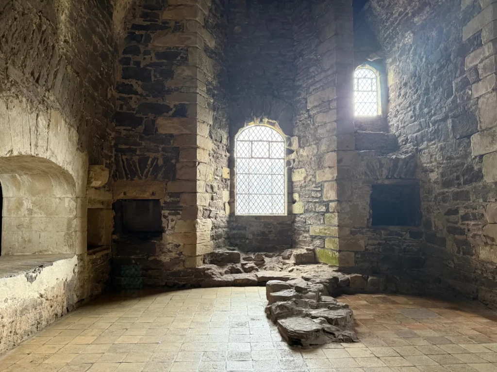 Habitación medieval de piedra con ventanas y chimeneas en el interior de Doune Castle, Escocia.